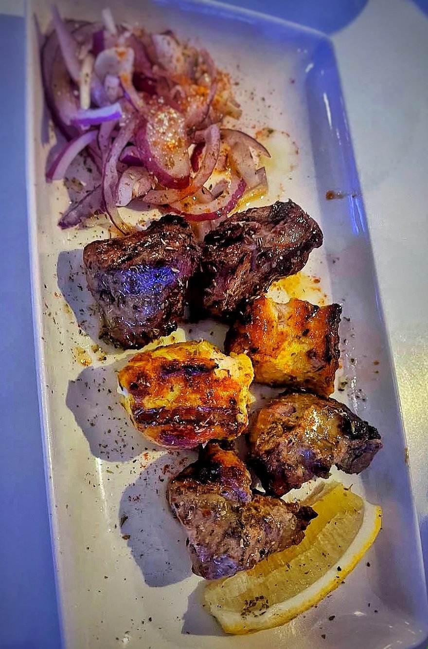 Round five of Zorba's meze — a selection of grilled chicken, pork and lamb with red onion, potato and lemon